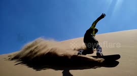 Slowmo footage of man sandboarding down dunes in Chile's Atacama Desert