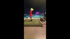 Shane Sky 4 years old.  Smashing golf ball at top golf. lf