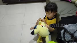 Adorable toddler feeding food to his Pikachu Toy