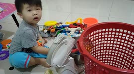 Funny toddler uses kitchenware as his play toy