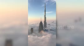 Stunning video shows the world's tallest building piercing through a blanket of fog towards the sky