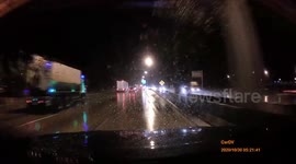 Garbage truck loses control on wet road and topples over into oncoming car