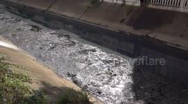 Volunteers clean out thick layer of black gunk from canal bottom in Thailand