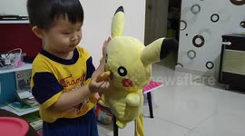 Funny 2-year-old toddler feeding his toy food