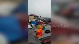 Desperate families shelter on roofs as Typhoon Vamco causes severe flooding in the Philippines