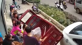 Car crash pins two pedestrians under parked three-wheeler in China