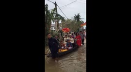 The bride and groom have to travel by boat through floodwaters on their wedding day