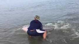 Heartwarming moment stranded pink dolphin is rescued in Thailand