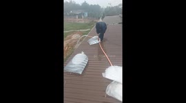 Vietnamese homeowners weigh down roofs with water-filled bags as Typhoon Vamco approaches