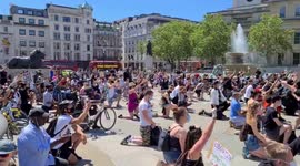 Black Lives Matter protestors take to their knees, raise their fists, and chant George Floyd in Trafalgar Square, London