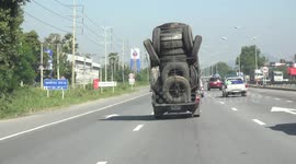 Overloaded pickup truck, loaded with old rubber car and truck tires.