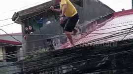 Brave father tightrope walks along electricity cables to collect food during Typhoon Vamco floods