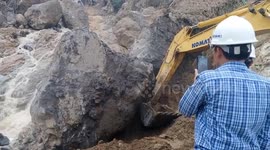 The excavator driver tried to push the giant rock to block the floodwater causing landslides
