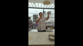 Vietnamese baker toss pizza dough professionally to the music
