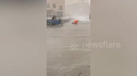 Gale force winds force struggling cleaner to crawl across road in China
