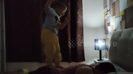 Adorable 2-year-old gives his dad comfortable massage by standing on his back