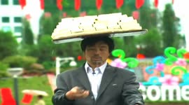 Delivery cyclist balances tray of tofu on his head