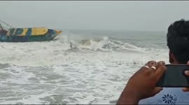 Locals nervously watch fishing boat struggle in rough sea as Cyclone Nivar approaches India