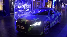 A car among illuminated arches of South Molton Street Christmas lights in Mayfair