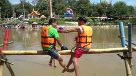 Thai locals have boxing match on bamboo poles over river