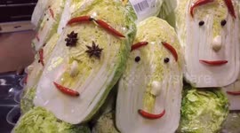 Supermarket employee uses dry chillies and garlic to put smiley faces on Chinese cabbages