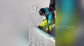 Hilarious moment father drags sleepy snowboarding toddler from slopes in northern China
