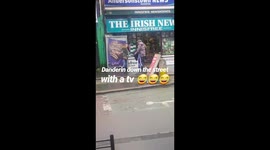 Man walking down the street with a stolen tv