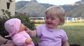 Cute baby cries every time her toy doll starts to cry