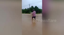 Man carries pet dog through floodwater as Thailand hit with deadly floods