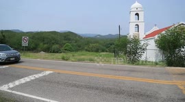 Cars traveling in front of a church by road in the Sierra de Mazocahui Sonora. highway