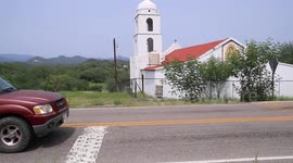 Cars traveling in front of a church by road in the Sierra de Mazocahui Sonora. highway