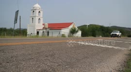 Cars traveling in front of a church by road in the Sierra de Mazocahui Sonora. highway