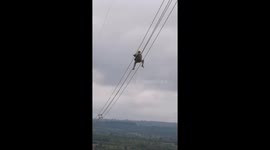Vietnamese workers walk on high-voltage power lines tens of meters high to repair
