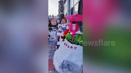 Elderly Chinese woman buys clothes to dress up snowmen in her yard