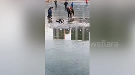 Spinning top enthusiasts use whips to rescue young man who fell into frozen lake in northern China