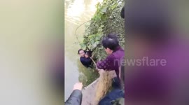 Group of people rescue man and boy trapped in river in China