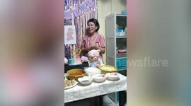 Couple hold gender reveal party by pulling long series of coloured tape from cake