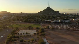 El Carcamo dirt sports fields in La Sauceda on December 10, 2020 in Hermosillo, Mexico. Baseball fields with the sun at sunset over the Cerro de la Campana.