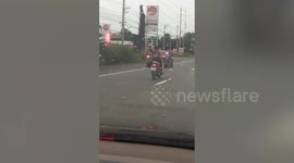 Daredevil motor scooter rider goes no-handed while reclining on motorway