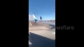Bizarre moment man climbs on wing of aeroplane in US airport