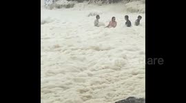 Beachgoers enjoy sea foam after Australia hit with heavy storms