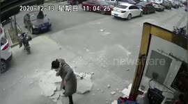 Wall crashes down from residential building in China and narrowly misses passersby