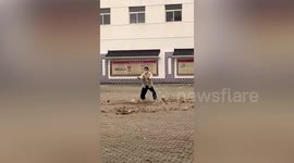 Chinese boy imitates an 'airbender' as leaves in the wind swirl around him