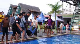 A car club member is thrown to the swimming pool for his membership acceptance celebration