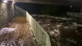 River bursts banks flooding road in Cornwall in the UK