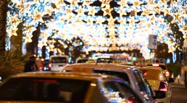 Footage of traffic on a road decorated with Christmas lights