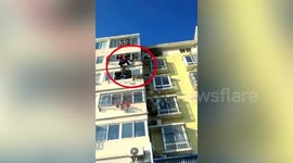 Neighbour holds up boy hanging from fourth-floor laundry rack until firefighters arrive in China