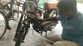 Snake handler having a miraculous escape from a cobra bite when he caught a cobra that was hiding inside the two wheeler in Southern India