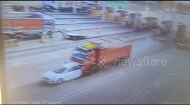 Speeding truck slams into car and pushes it through toll gate in India