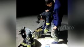 Chinese firefighters help each other to take off frozen uniforms after working four hours at the temperature of -26C